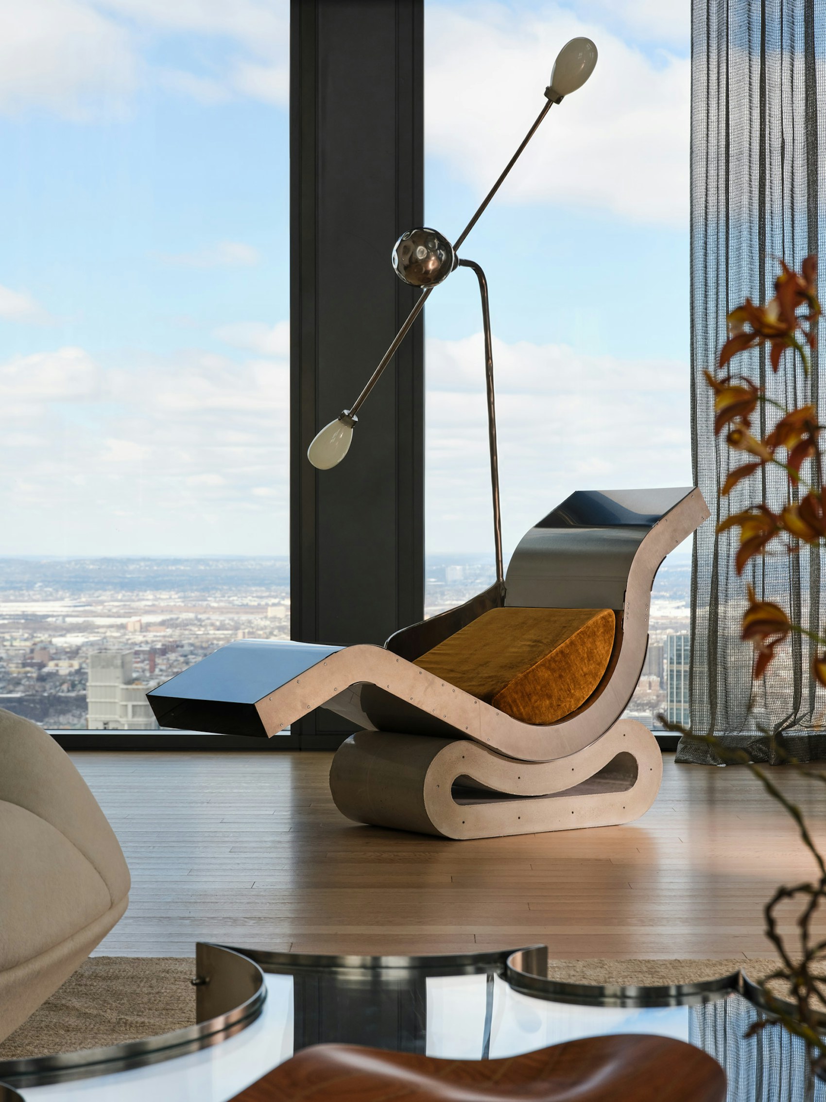 Sculptural Brazilian modernist lounge chair framing a city skyline at the Crossings exhibition